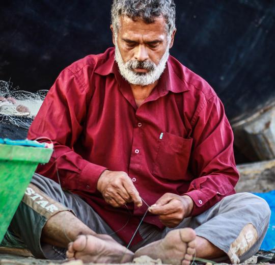 A fisherman fixing his nets. Photo: BASEL YAZOURI
