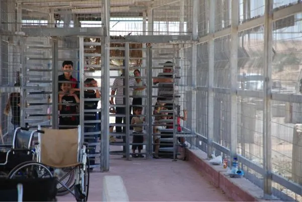 Palestinians passing through turnstile while crossing between Gaza and Israel and Erez.